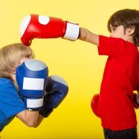 Mi állhat a magatartásproblémák hátterében? front-view-two-boys-sparring-boxing-gloves-yellow-wall