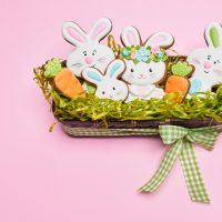 Húsvéti szokások gyerekekkel – ötletek, amelyek élménnyé válnak Ginger glazed cookies in box with grass.
